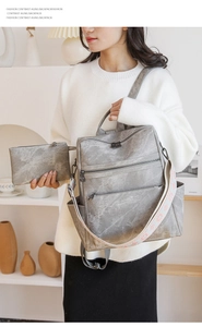 Dettaglio dello zaino vintage grigio con pochette e spallacci con motivi floreali colorati