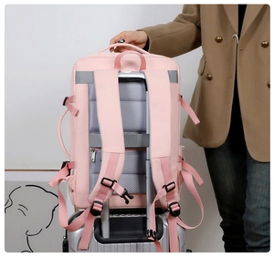 Pink travel backpack featuring a luggage strap for secure attachment to suitcase handles