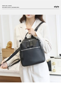 Close-up of black lychee grain PU leather backpack with silver metal zippers and hardware