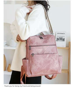 Dettaglio dello zaino vintage rosa con tracolla ricamata etnica e tasche con cerniera