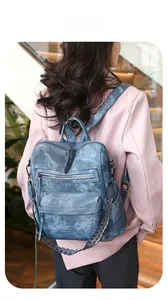 Rear view of a blue large capacity faux leather backpack with colorful woven strap detail
