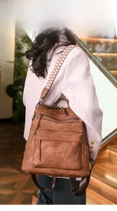 Detail of brown PU leather backpack featuring colorful woven straps and zipper pockets