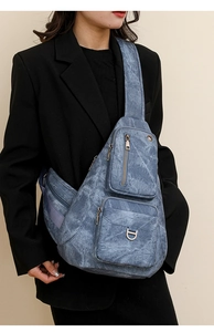 Détail du sac bandoulière en denim bleu avec doubles poches zippées et anneau en D