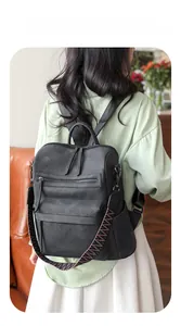 Close-up of black PU leather backpack featuring a stylish woven colorful shoulder strap