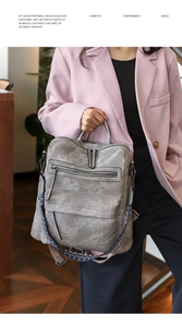 Detail of grey PU leather backpack featuring a stylish blue geometric woven wide strap
