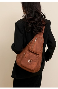 Vue arrière du mannequin portant un sac de poitrine vintage en cuir marron et un blazer