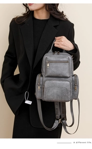 Detail of dark grey retro PU leather backpack with vintage matte finish and multi-pockets