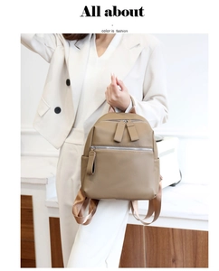 Detail of khaki PU leather backpack with lychee texture held by a model in white
