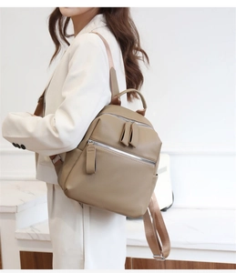 Khaki pebbled PU leather backpack worn by model in a white professional studio setting