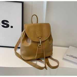 Detail view of the brown PU leather backpack featuring a metal hook closure and drawstring