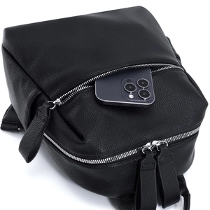 Détail d'un sac à dos en cuir noir montrant un smartphone dans sa poche extérieure