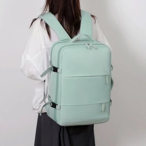 Large mint green travel backpack with multi-compartments shown on model for business and travel
