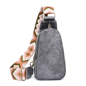 Detailed view of grey PU leather chest bag featuring colorful geometric jacquard wide strap