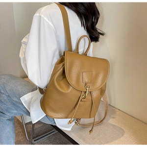 Detail view of mustard yellow vintage PU leather backpack with lychee grain texture