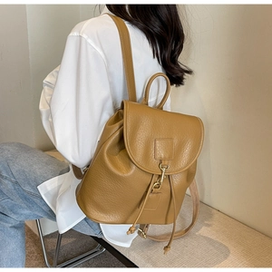 Close-up of vintage camel PU leather backpack with pebble grain texture and metal hook closure