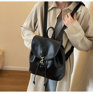 Close-up of black pebble texture PU leather backpack with gold hardware and drawstring