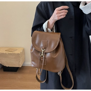Detailed texture of dark brown lychee grain PU leather backpack with gold hardware