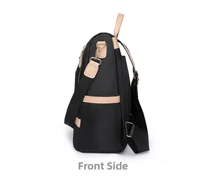 Side view detail of black nylon backpack with brown leather straps and gold metal zippers