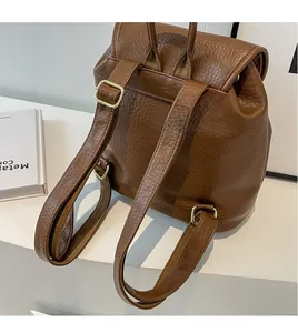Detailed back view of a brown pebbled PU leather backpack with adjustable gold hardware