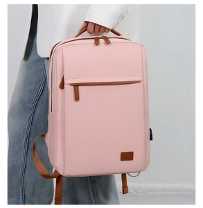 Λεπτομέρεια ροζ σακιδίου από ύφασμα oxford με καφέ δερμάτινες λαβές και φερμουάρ