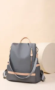 Detail of grey nylon backpack for women showing A4 size capacity and leather accents