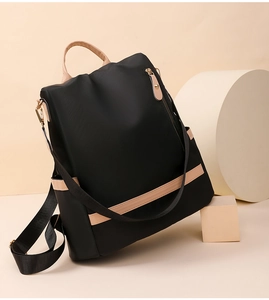 Detail of minimalist nylon backpack with beige leather handles on geometric stands
