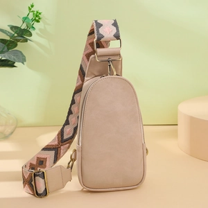 Detail of beige PU leather chest bag with geometric jacquard strap and gold hardware