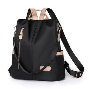 Detail of black nylon backpack featuring gold hardware and removable shoulder strap