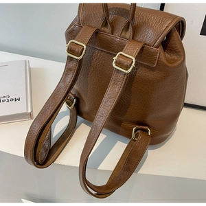 Detail of dark brown faux leather backpack back view with adjustable straps and gold buckles