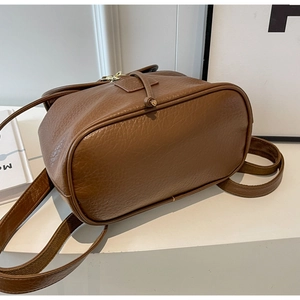 Detail view of the brown lychee pattern leather base and neat stitching of the backpack