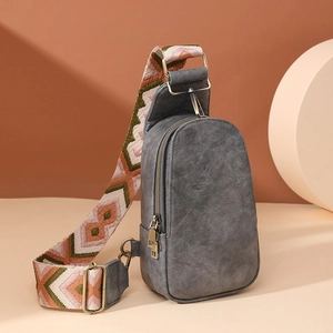 Macro detail of vintage grey textured chest bag with wide geometric patterned strap