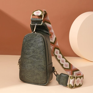 Detail of dark green vintage leather waist bag with colorful geometric embroidery strap