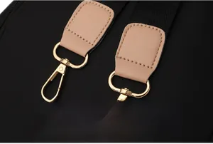 Detail of detachable shoulder strap with golden metal hooks and leather reinforcement