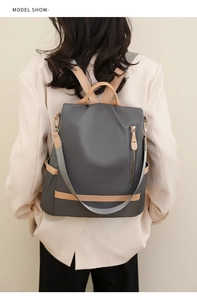 Rear view of a model wearing the high-capacity nylon backpack in dark grey and khaki colors