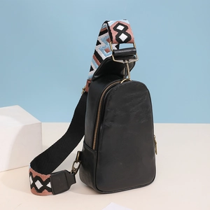 Detail of black matte leather chest bag with a colorful ethnic geometric woven strap