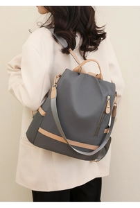 Close-up of minimalist nylon backpack in grey and khaki with side zipper detail