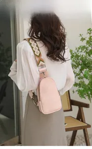 Pink faux leather crossbody bag with vintage geometric woven wide shoulder strap