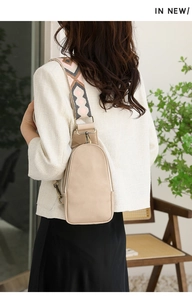 Chic beige leather waist bag with a patterned jacquard strap worn by a model in style