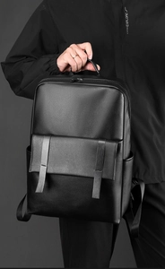 Vue détaillée du sac à dos d'affaires en cuir noir avec rabat et sangles doubles