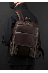Détail de la texture cuir marron foncé et de la fermeture éclair argentée du sac à dos business