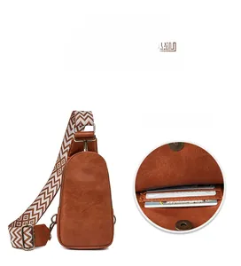 Detail view of brown leather chest bag showing functional front card slot compartment
