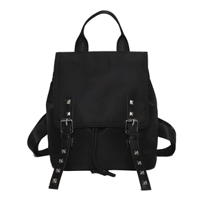 Minimalist black nylon backpack with flap closure and silver stud details on front