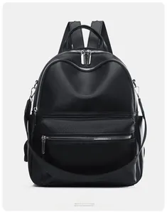 Front view of black pebbled leather backpack with multiple silver zipper pockets