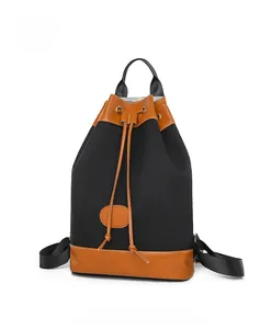 Detailed front view of black Oxford fabric backpack with brown leather trim and drawstrings