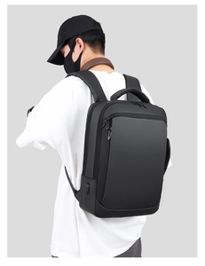 Slim black business laptop backpack with USB charging port shown on male model