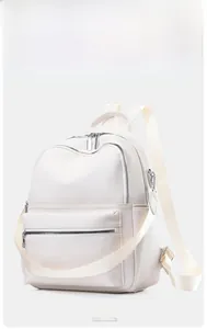 Detail view of cream PU leather backpack featuring lychee texture and silver metal zippers