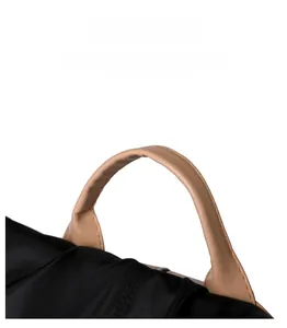 Close-up of a nylon backpack with a durable khaki leather handle and detailed stitching