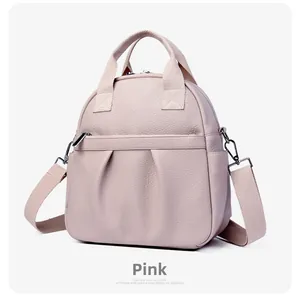 Dettaglio dello zaino rosa in pelle PU martellata con doppi manici e tasca frontale zip