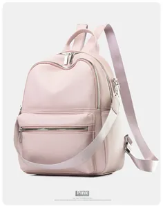 Detailed macro view of pink pebbled faux leather texture and silver zipper of the backpack