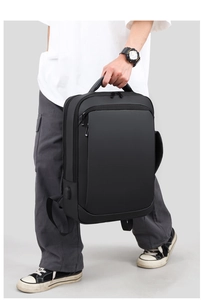 Detail of black business backpack featuring a padded handle and external USB charging port